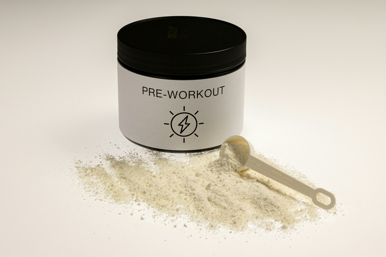 a jar of pre - workout powder next to a spoon